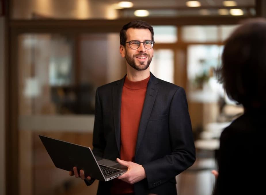 Medarbetare på Valea står med en dator i famnen